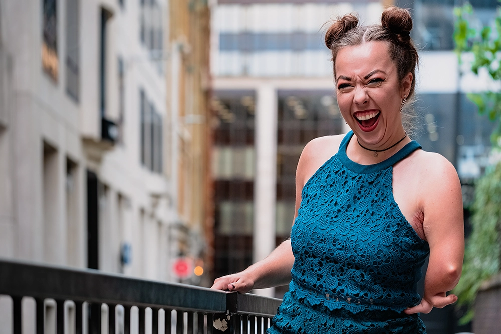 Disability advocate and influencer, Jessica Jordan Ping photographed laughing intensly at camera on the streets of London.