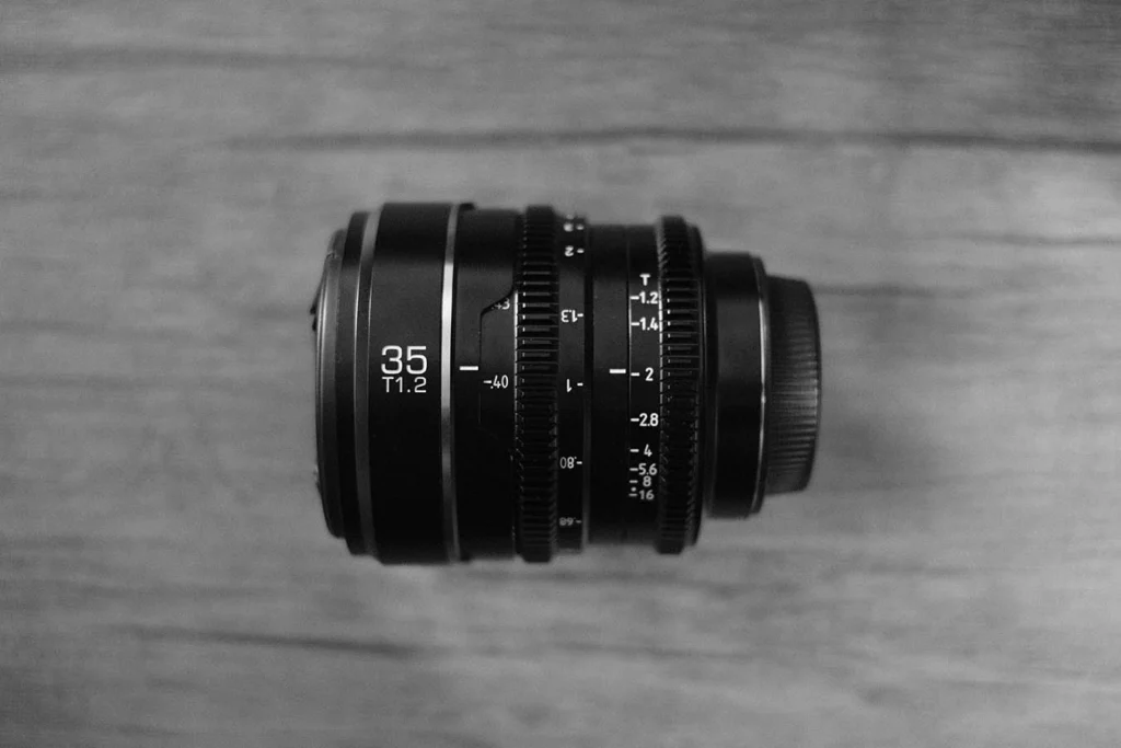 Overhead black and white shot of a Sirui Nightwalker X-mount lens, specifically the 35mm T/1.2 model.